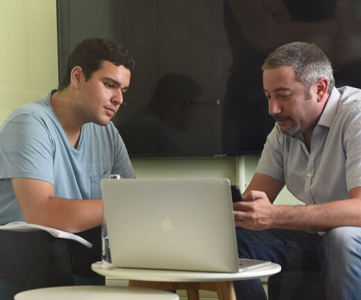 Image of two lumen employees working and looking at a computer
